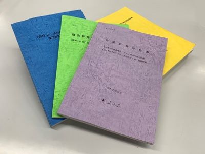 青、緑、紫、黄色の4冊の報告書